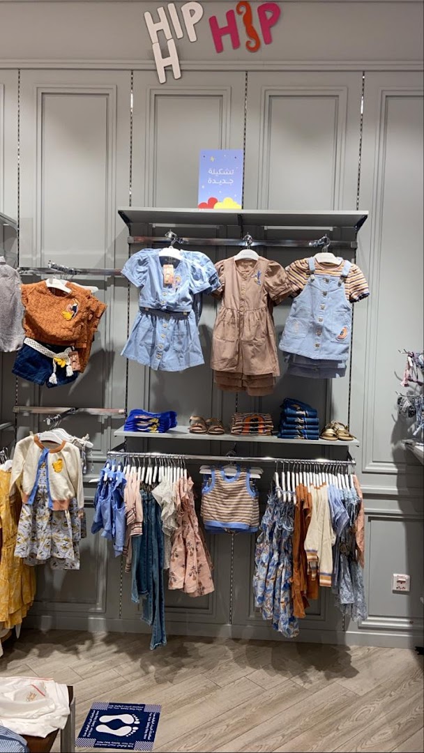 A well-lit retail display featuring a variety of children's clothing on hangers and shelves.