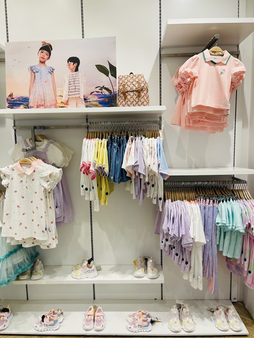 A well-organized display of children's clothing and shoes in pastel colors.