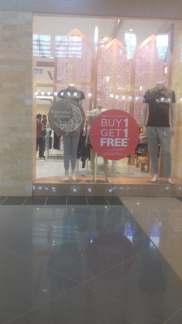 Giordano shop window display featuring mannequins and a 'Buy 1 Get 1 Free' promotion.