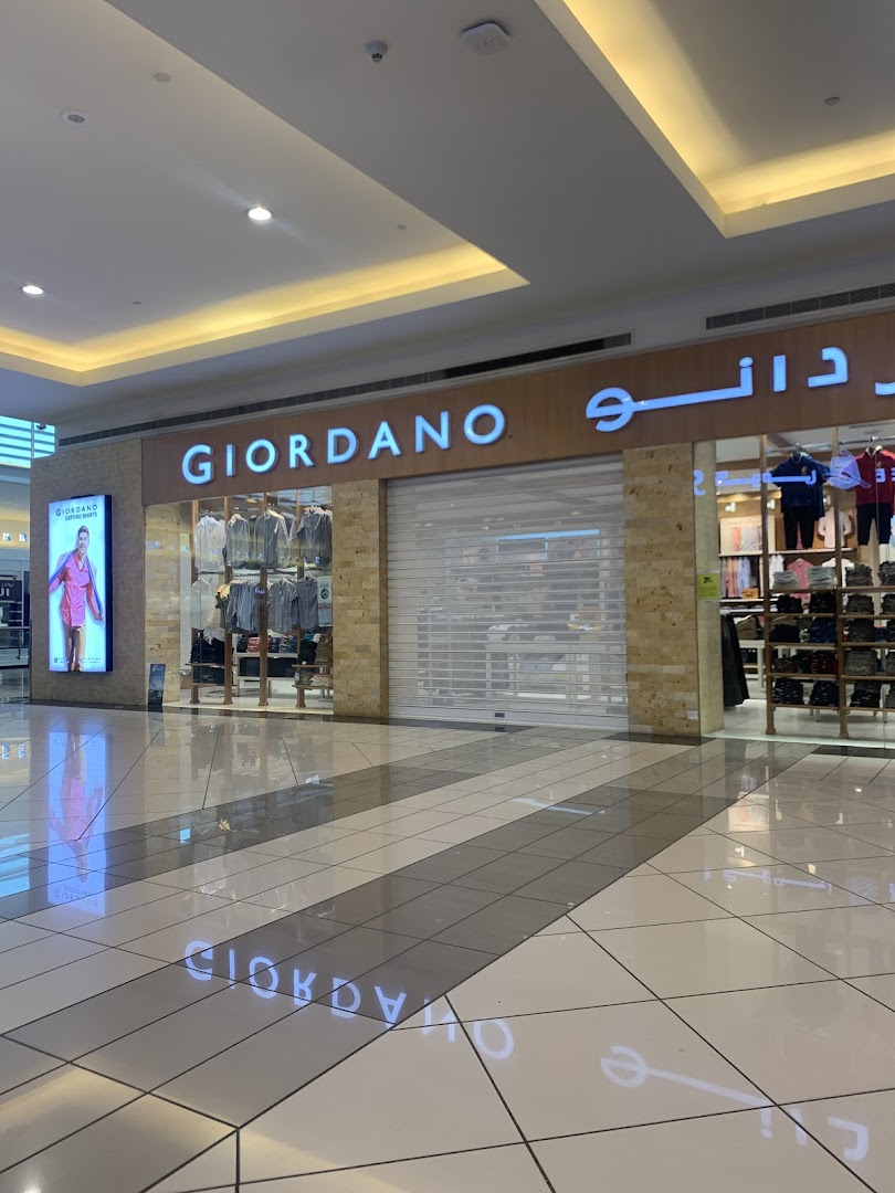 The GIORDANO shop front with its illuminated sign and display window.