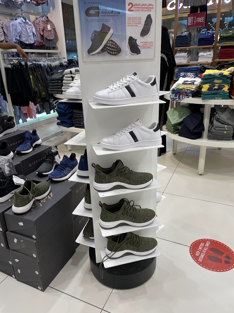 A display of Giordano shoes and clothing inside a retail store.