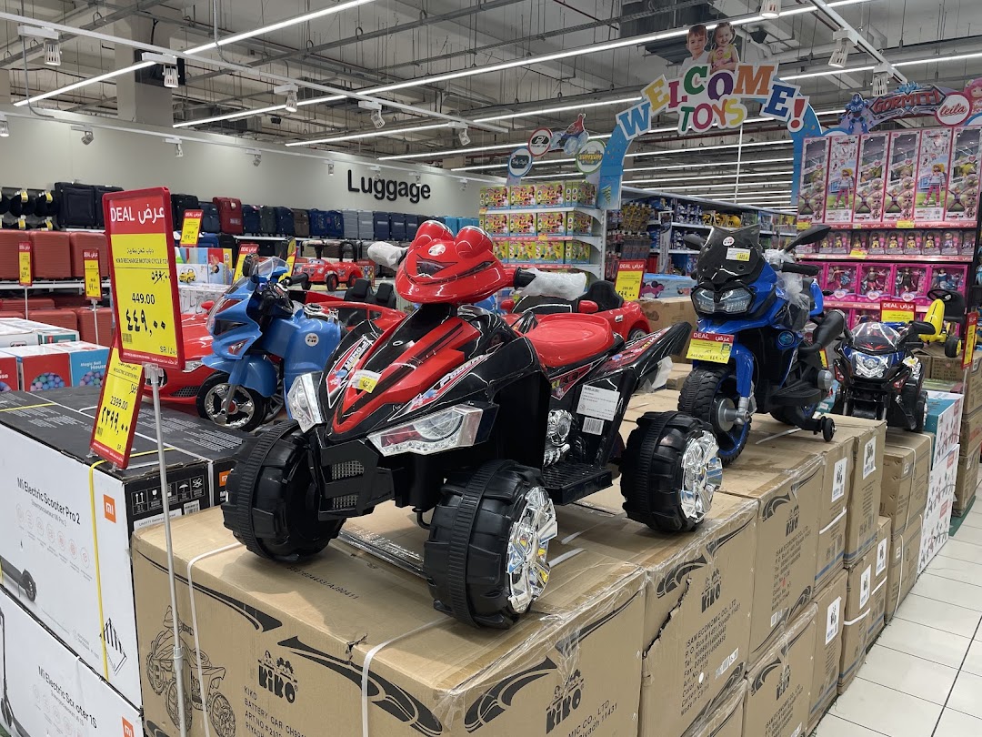 A variety of ride-on toys, including motorcycles and ATVs, displayed in a retail store.