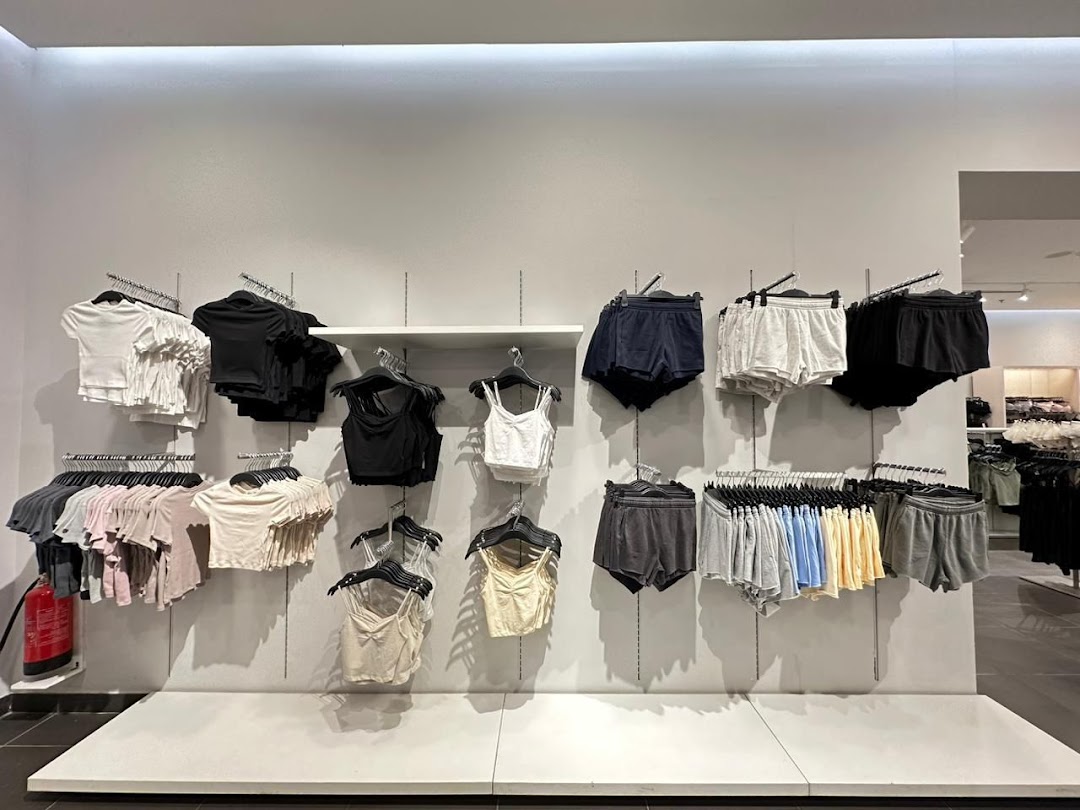 A display of women's casual wear, including t-shirts and shorts, neatly arranged on hangers.