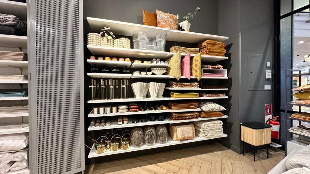 Shelves filled with home decor items like pillows, vases, candles, and blankets.
