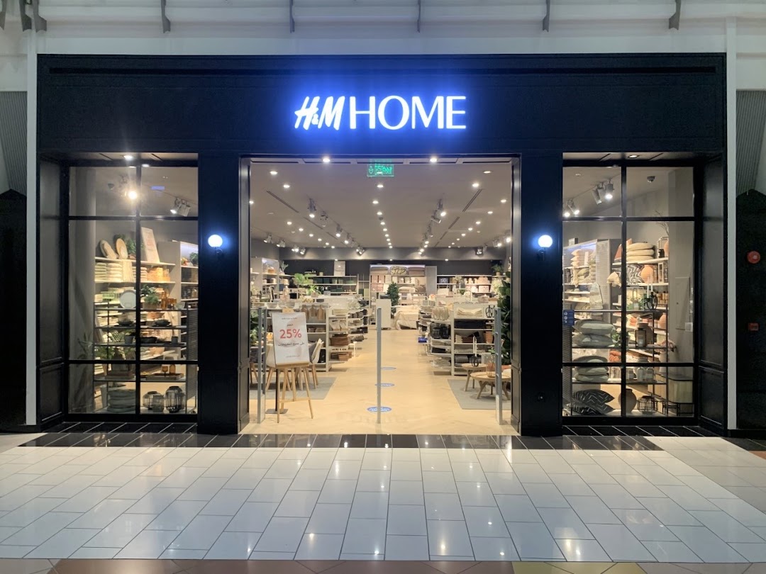 The entrance of an H&M Home store, showcasing home decor items and a 25% off sign.
