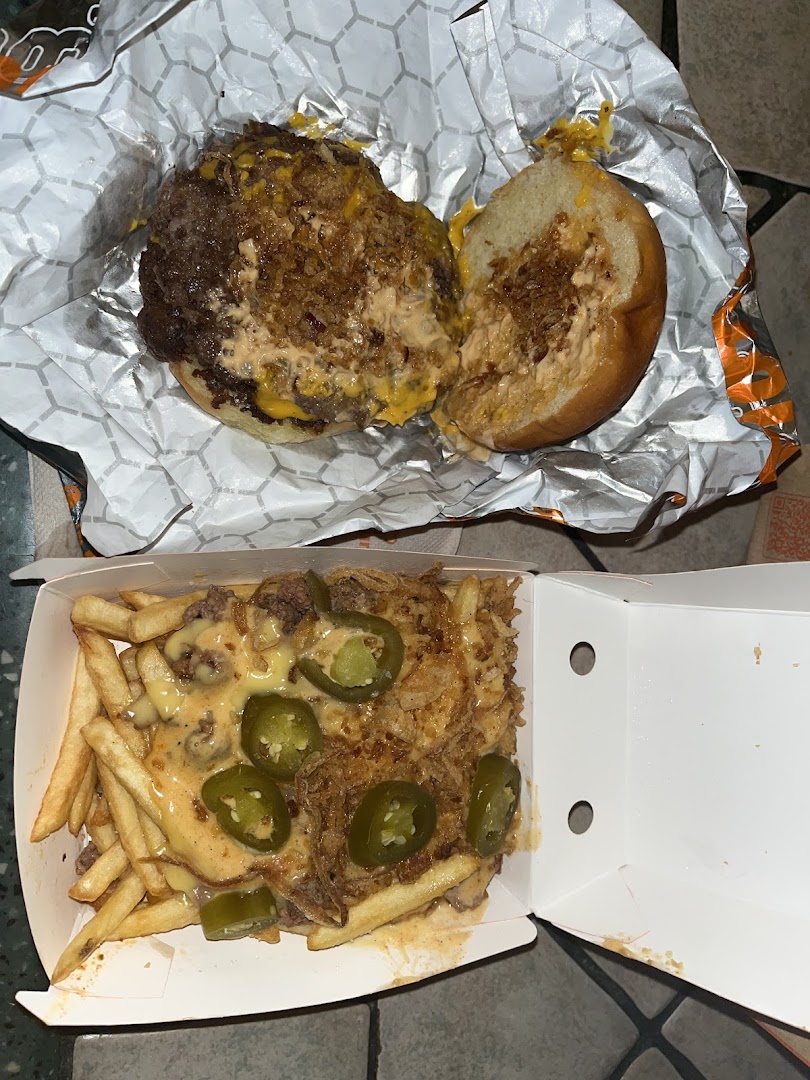 A delicious-looking burger and loaded fries with jalapeños and cheese.