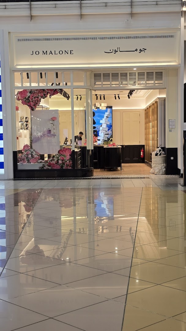 The elegant Jo Malone shop front features a large display window with floral arrangements and product displays.