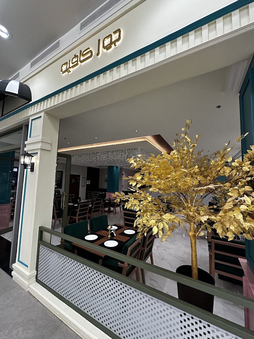 The entrance to Joe's Cafe, featuring elegant seating and a decorative golden tree.