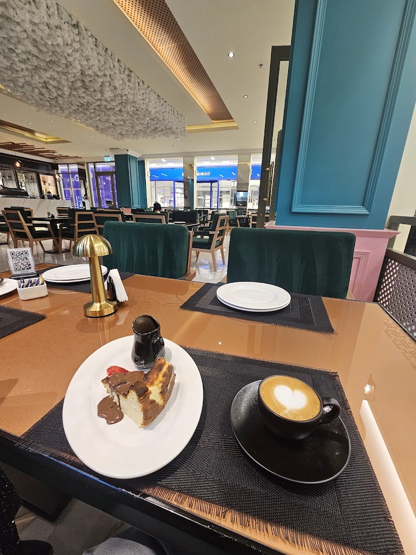 A table at Joe's Cafe with a slice of cheesecake and a latte.