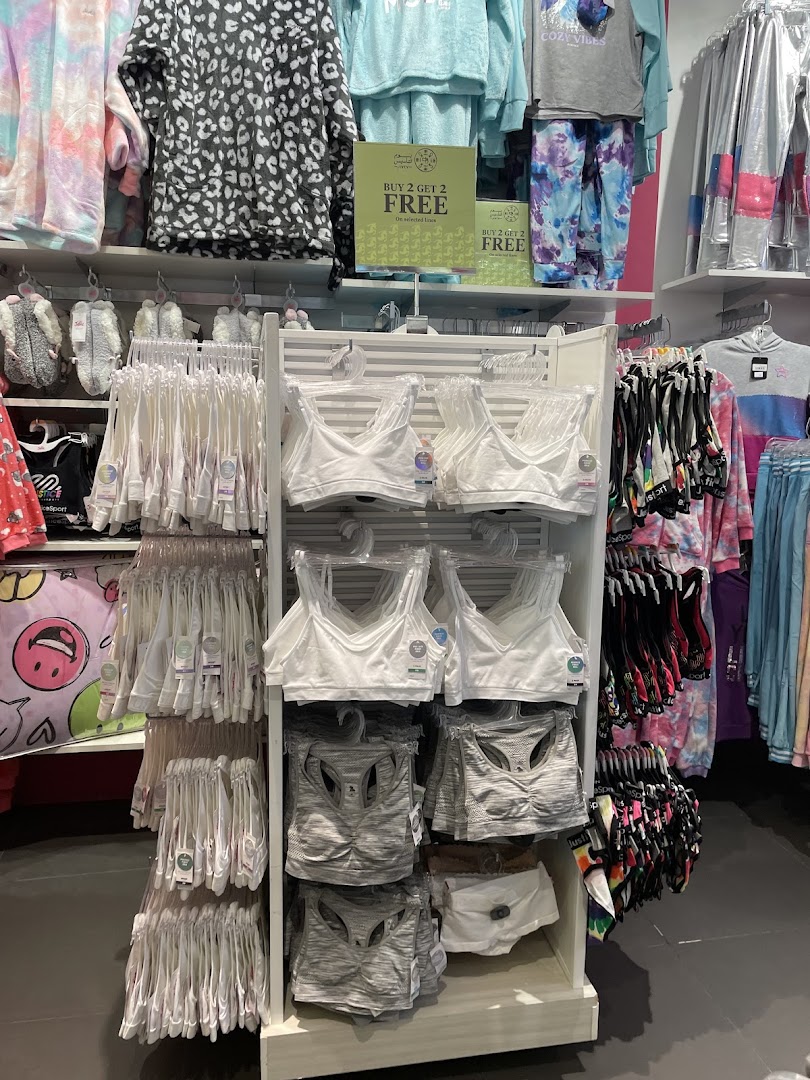 A display of girls' athletic wear, including sports bras and loungewear, at Justice.