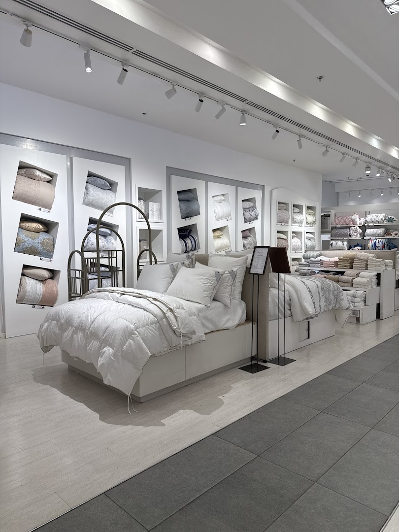 Interior view of Karaz Linen shop showcasing beautifully displayed bedding sets on beds.