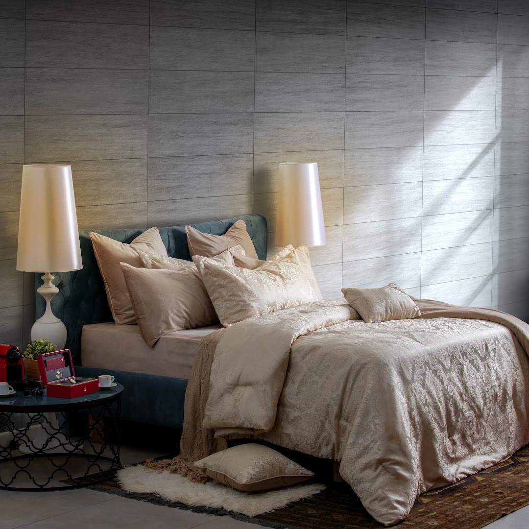 A luxurious bedroom setting with a plush bed, elegant lamps, and decorative pillows.