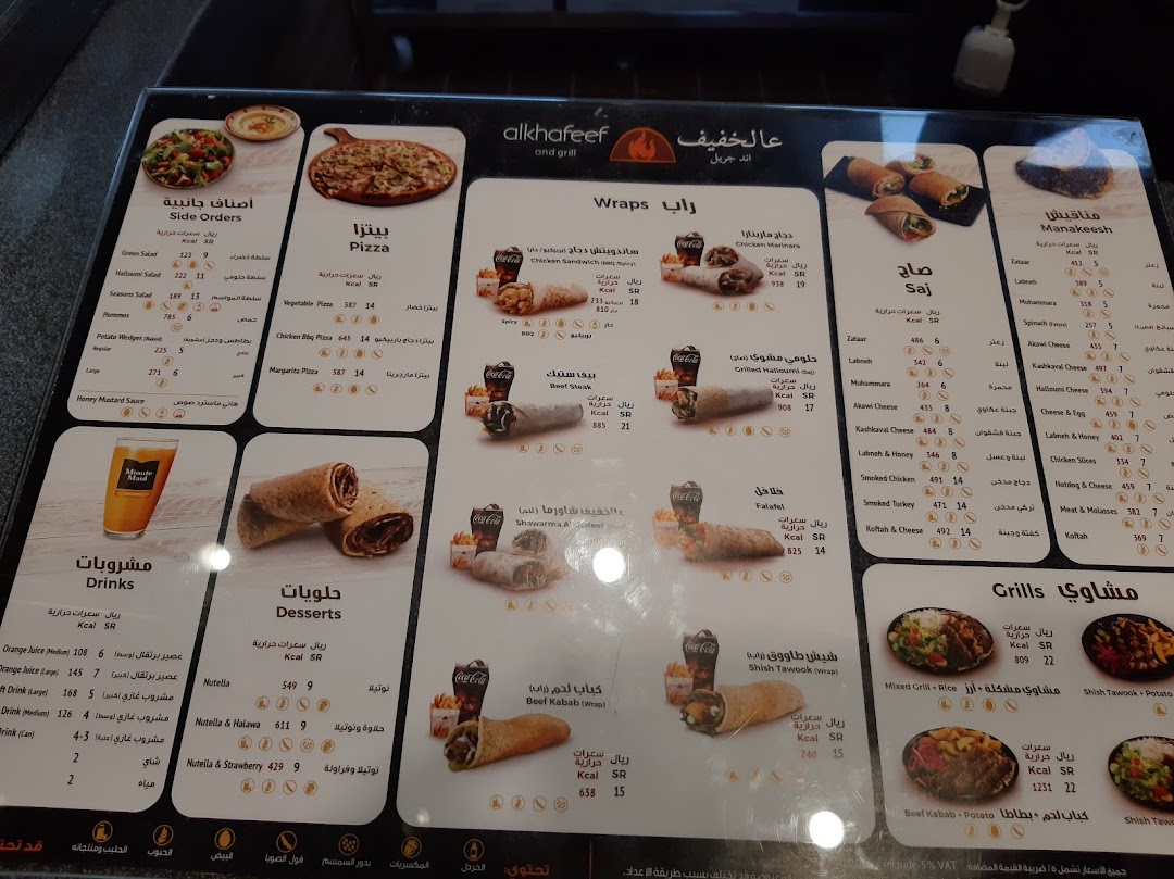 A menu board displaying various food items like pizzas, wraps, manakeesh, grills, drinks, and desserts.