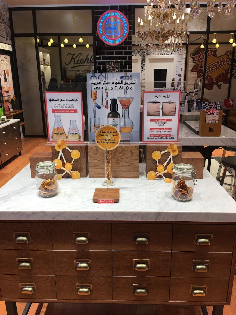 Kiehl's store display featuring Vitamin C products and before/after skin treatment visuals.