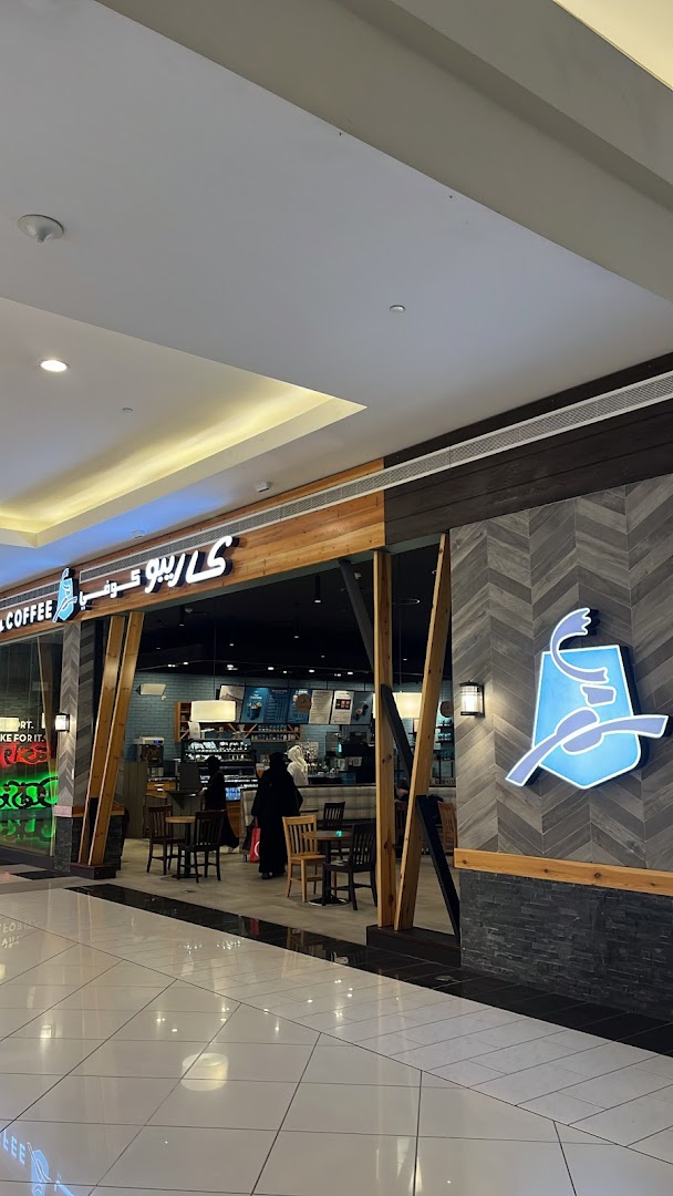 The exterior of a Caribou Coffee shop with its distinctive logo and inviting seating area.