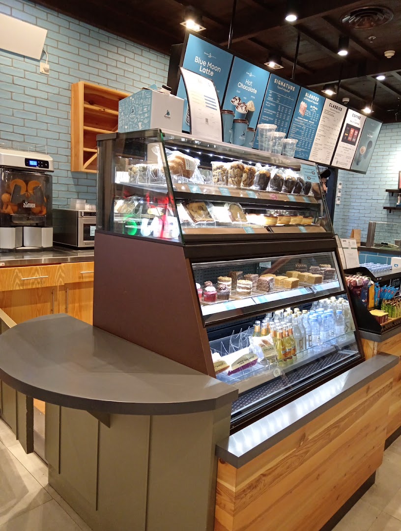 A display case filled with pastries, cakes, and beverages at Caribou Coffee.