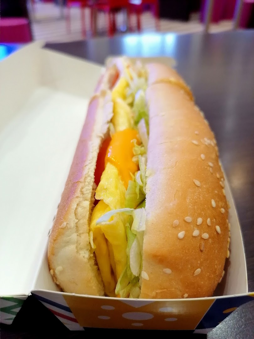 A close-up shot of a delicious hot dog with lettuce and cheese in a bun.