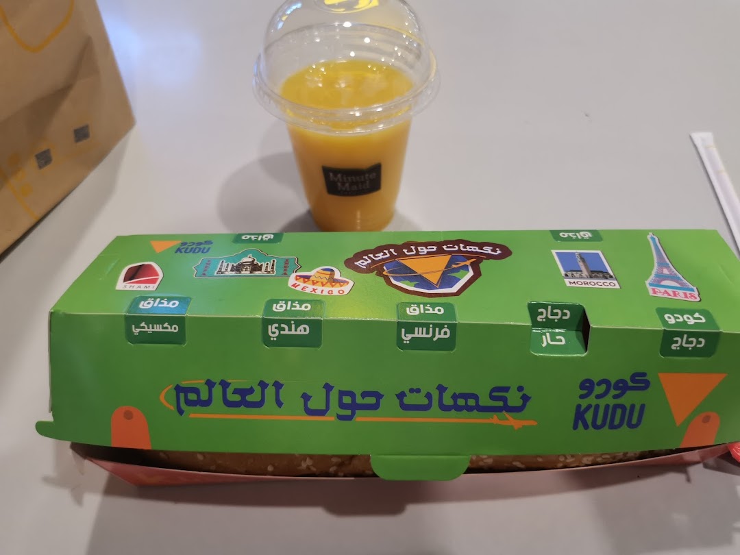 A Kudu meal box with a drink, featuring international flavors and landmarks.