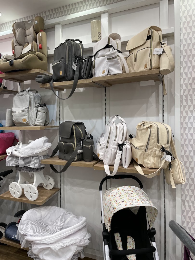A retail display featuring baby strollers, car seats, and diaper bags in various colors.