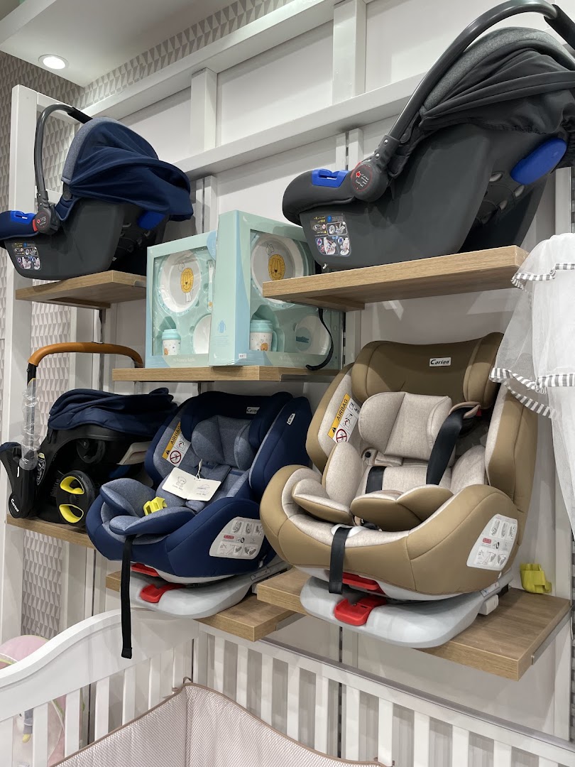 A display of car seats and baby tableware on shelves in a retail store.