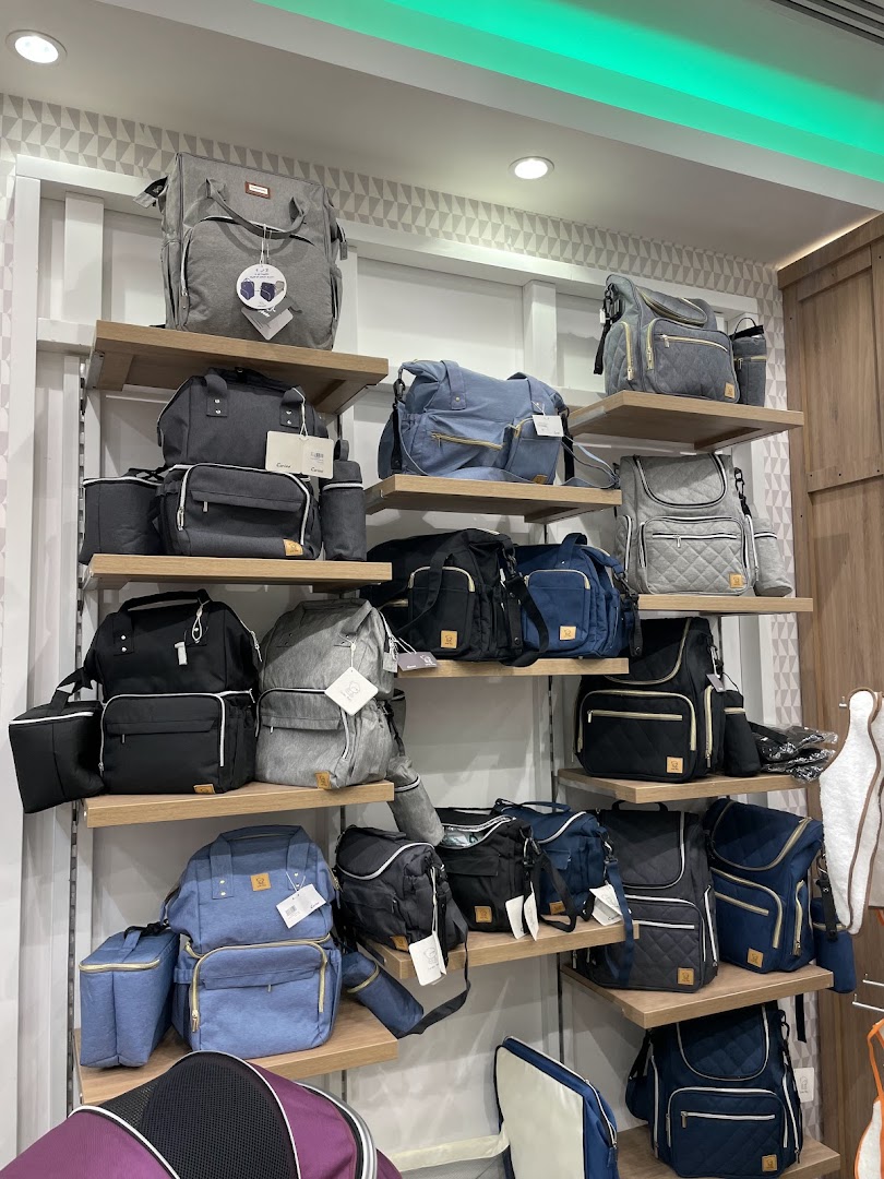 A display of various diaper bags and backpacks in different colors and styles on shelves.