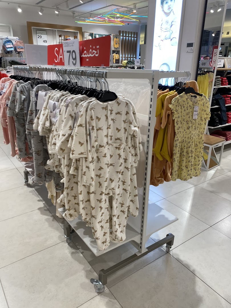 A display of children's sleepwear and dresses on racks inside a retail store.