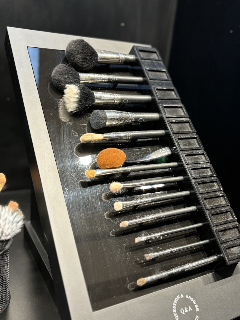 A display of various makeup brushes neatly arranged on a black stand.
