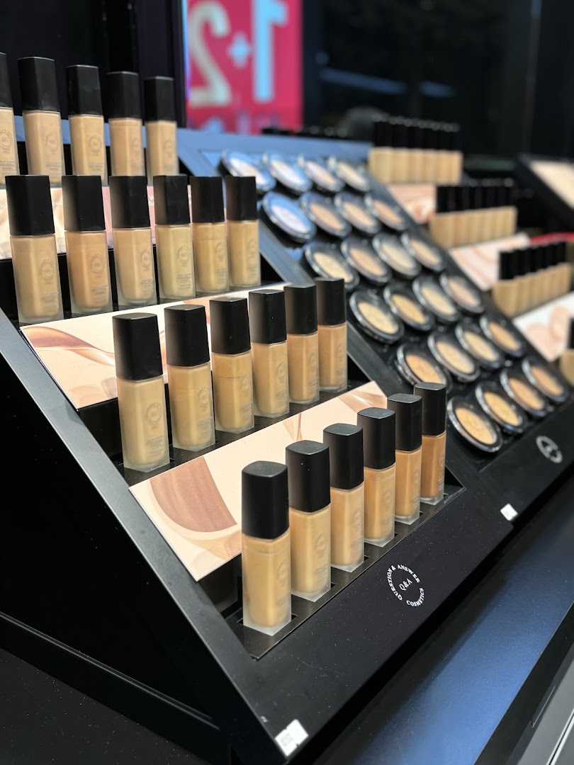 A display of various foundation bottles and compact powders from the QA cosmetics brand.