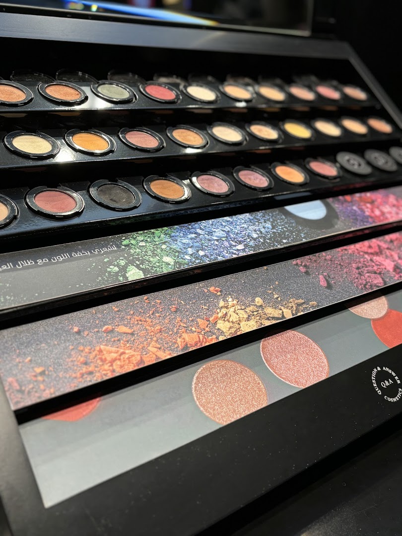 A display of various eyeshadow palettes and makeup products in a retail setting.