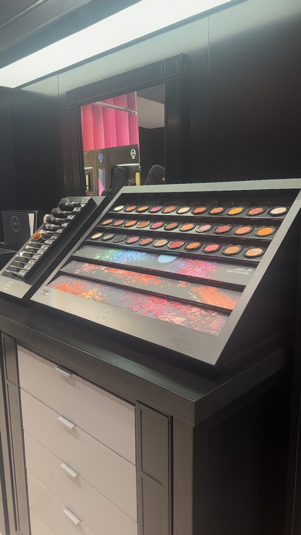 A display of makeup palettes and brushes in a retail store.