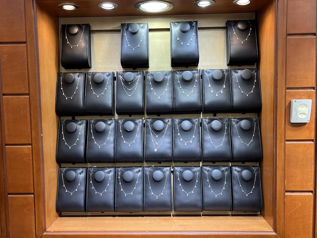 A display of delicate necklaces on black stands in a jewelry store.