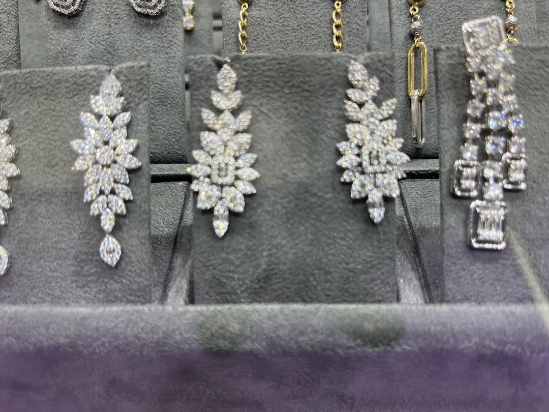 Close-up of sparkling diamond earrings displayed on grey velvet stands.