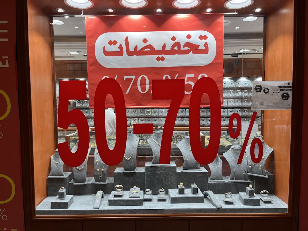 A jewelry shop window displaying a 50-70% off sale with various necklaces and rings.
