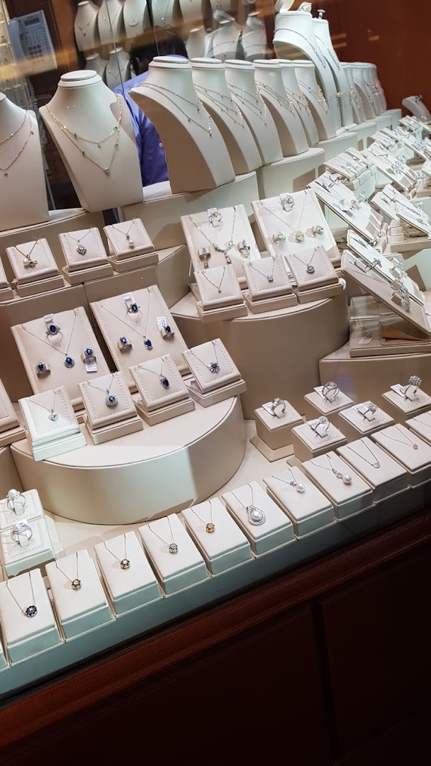 A display of exquisite necklaces and rings, showcasing fine jewelry with diamonds and gemstones.