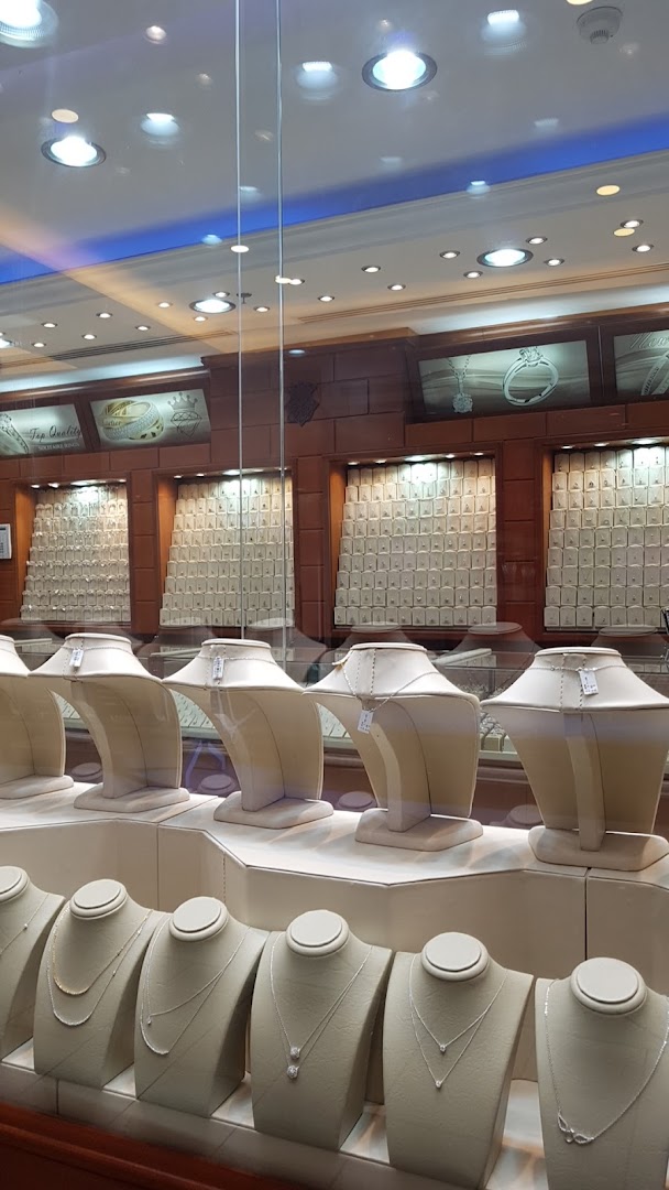 A jewelry store display featuring necklaces on mannequins and various jewelry pieces in cases.