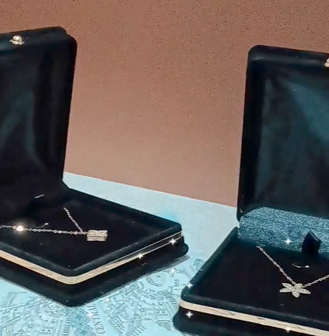 Two elegant necklaces displayed in open jewelry boxes, showcasing exquisite craftsmanship.