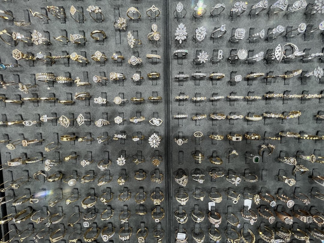 A display of various rings, including diamond and gold, arranged on black velvet stands.