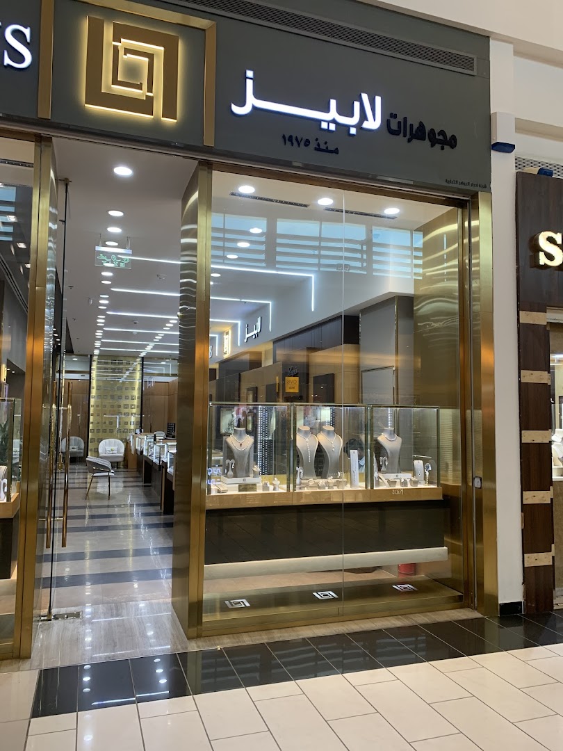 The exterior of a luxurious jewelry store with illuminated signage and display cases.