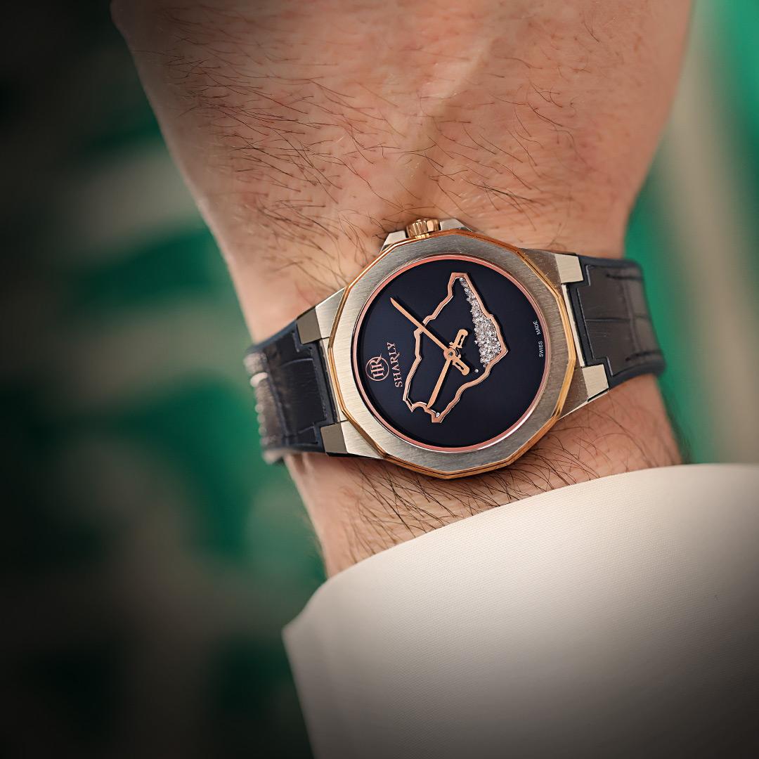A close-up shot of a man wearing a luxury watch with a dark dial and diamond accents.