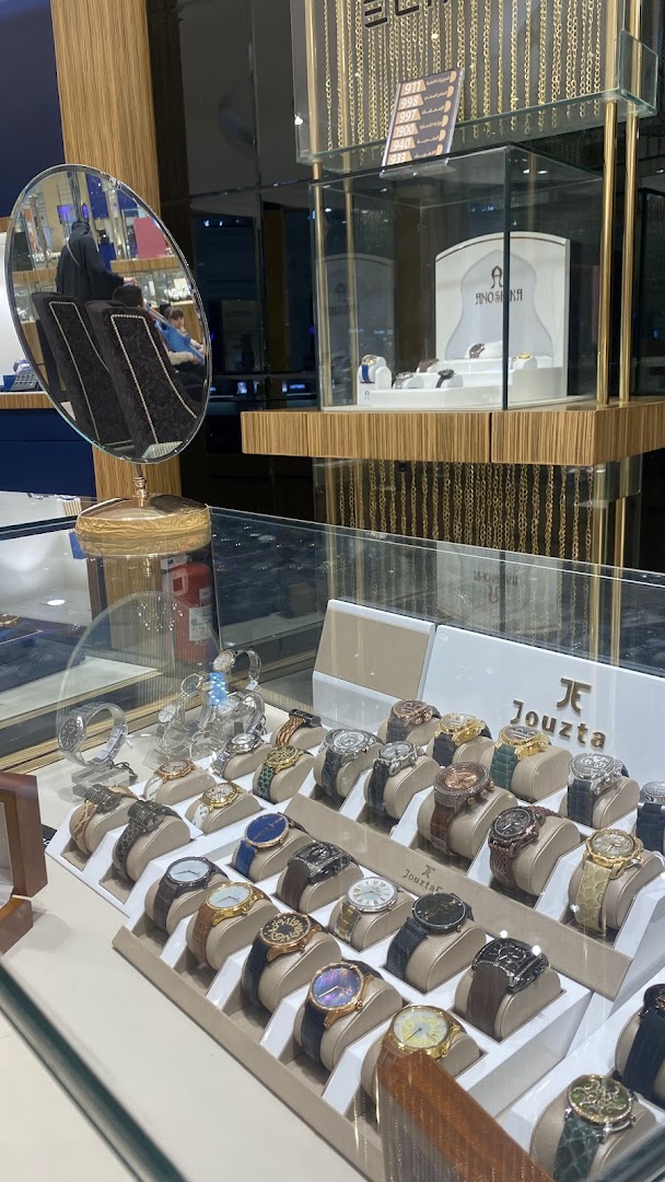 A display of luxury watches from Jouzta and other brands in a well-lit retail store.