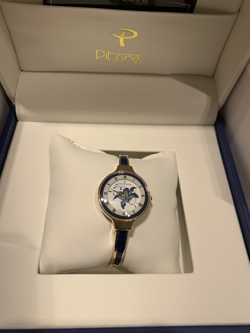 A gold and blue women's watch with a floral design is displayed in its box.