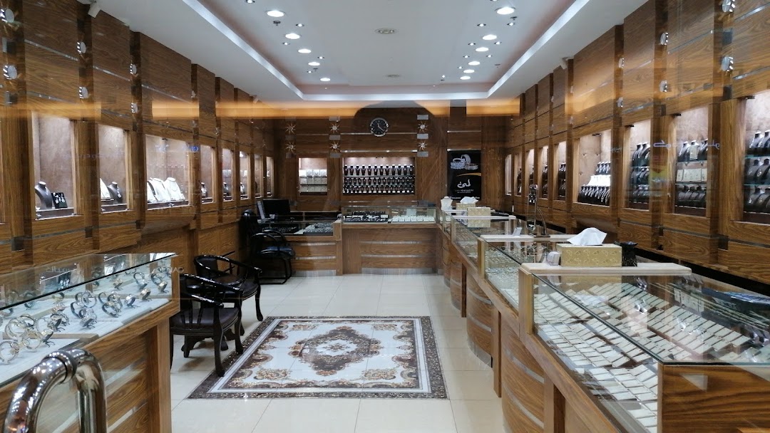 Interior view of a well-lit jewelry store with display cases filled with watches and necklaces.