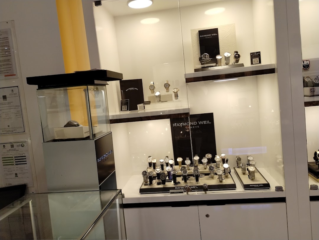 A well-lit display case showcasing a variety of Raymond Weil watches.