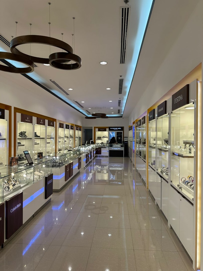 Interior view of a modern watch store showcasing display cases filled with various timepieces.
