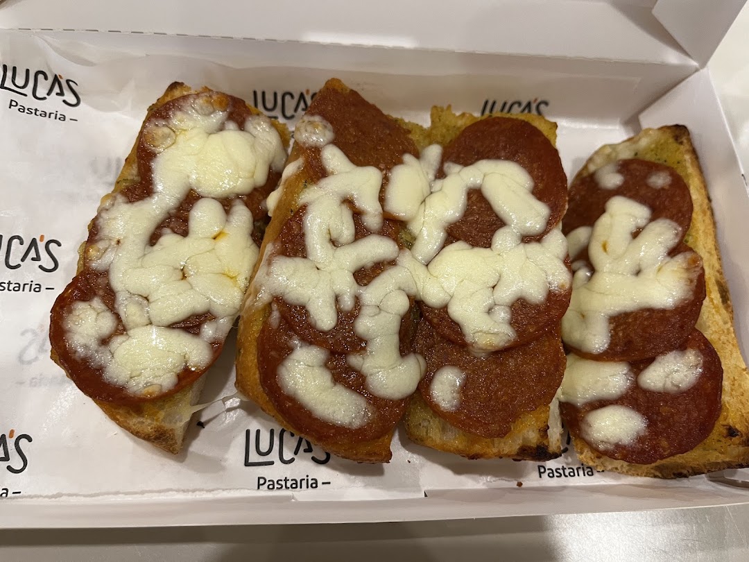 Three slices of pepperoni and cheese pizza toast in a white box.