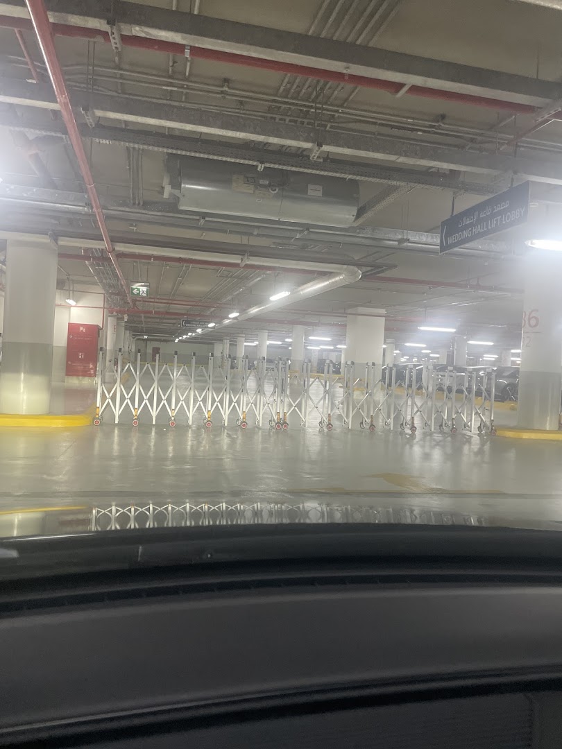 Interior view of a parking garage with retractable barriers and signage.