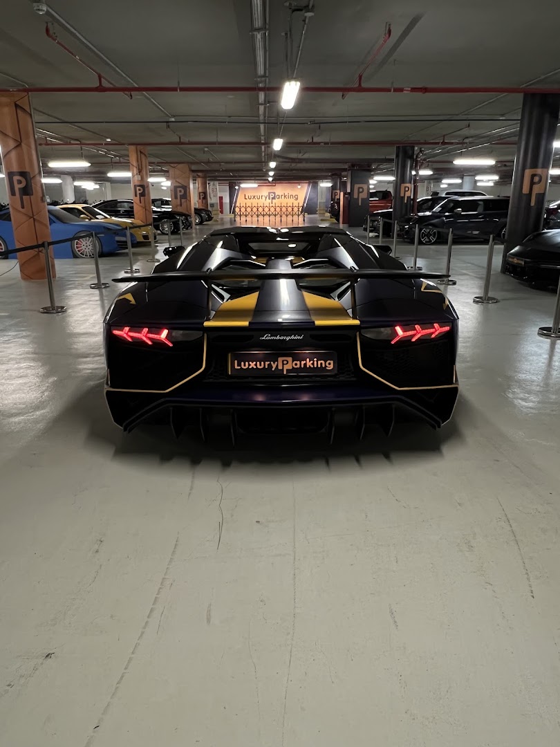 A luxury sports car parked in a well-lit, modern parking garage with other vehicles.
