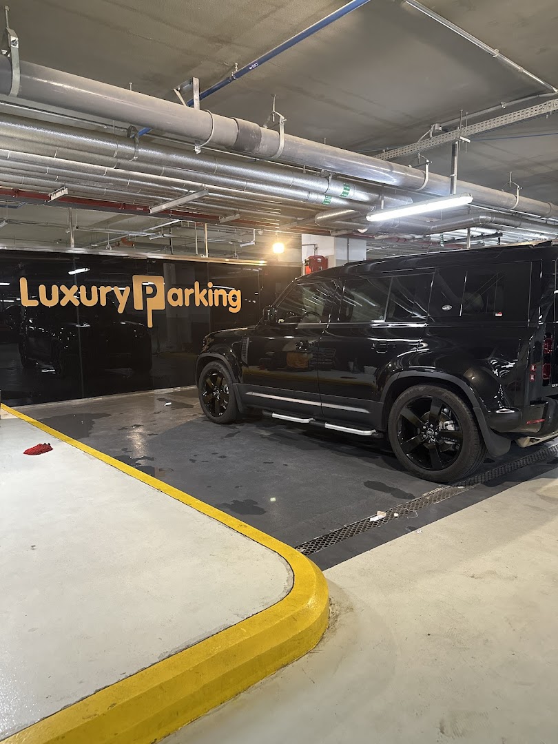 A black luxury SUV parked in a clean, well-lit parking garage with the "Luxury Parking" logo visible.