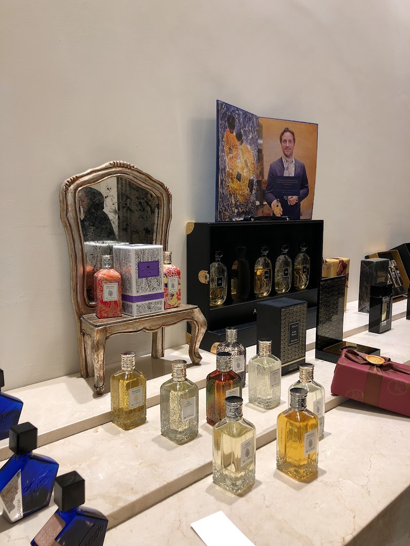 A display of various perfume bottles and gift boxes on a marble counter.
