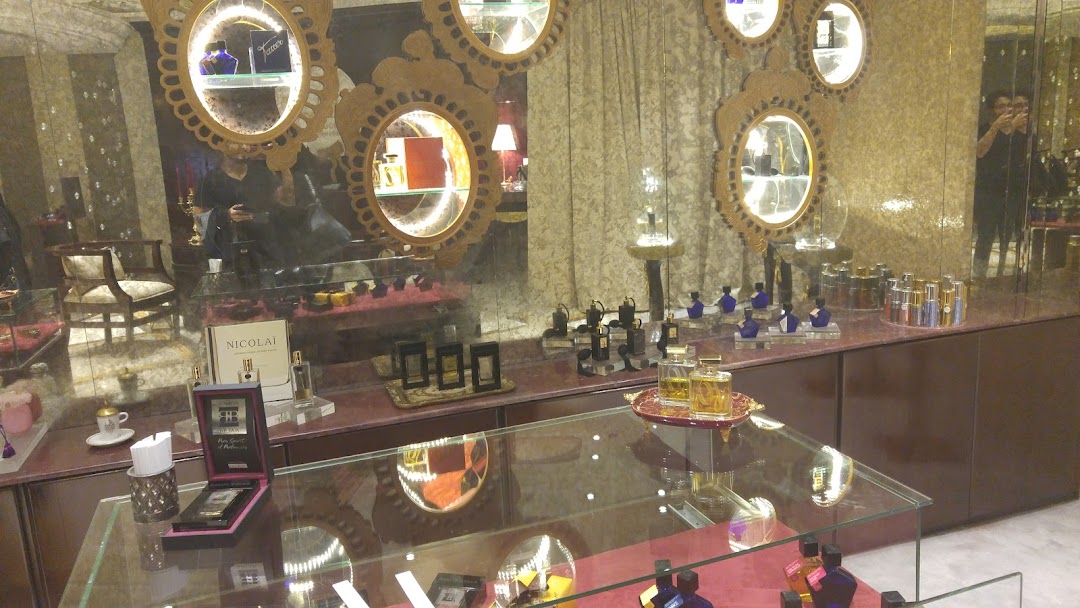 Interior view of a luxury perfume shop with display cases showcasing various fragrances.